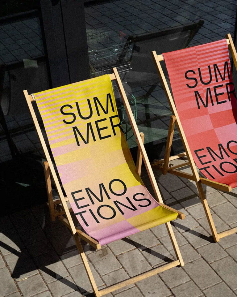 Zwei Liegestühle mit Schriftzug 'Summer Emotions' auf Pflastersteinen