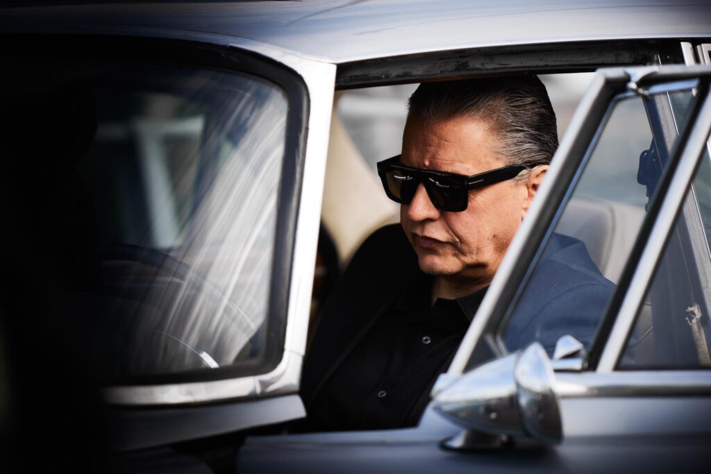 Mann mit Sonnenbrille in einem klassischen Auto