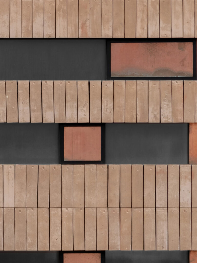 Moderne Fassade mit geometrischer Anordnung aus Backstein und Glas.
