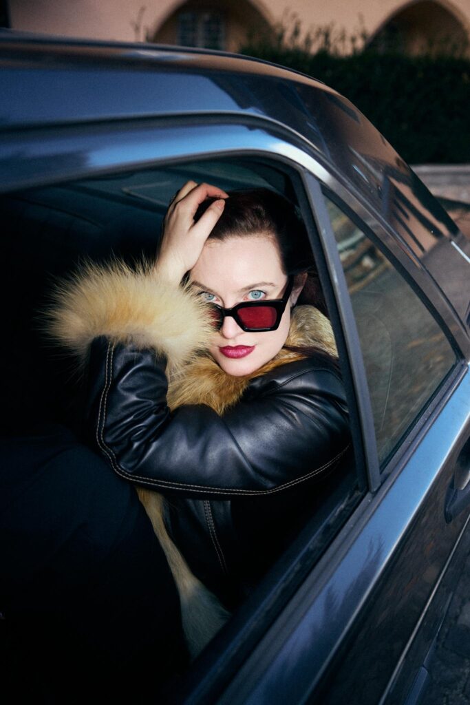 Frau mit Sonnenbrille im Auto, energischer Blick