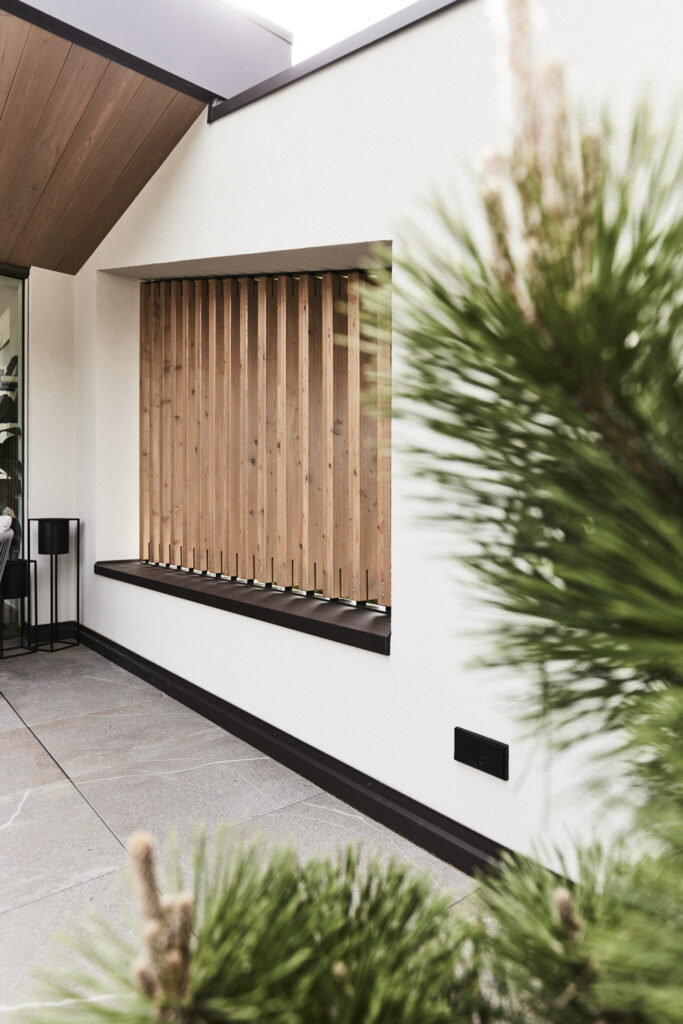 Moderner Terrassenbereich mit Holzkonstruktion und Pflanzen.