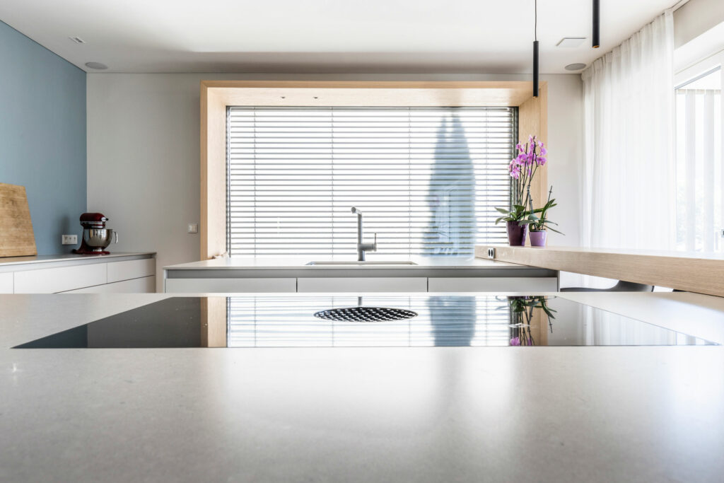 Moderne, helle Küche mit Induktionsherd und Orchidee am Fenster