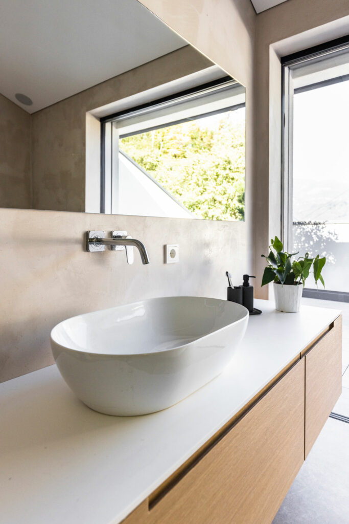 Modernes Badezimmer mit ovalem Waschbecken und Blick ins Grüne