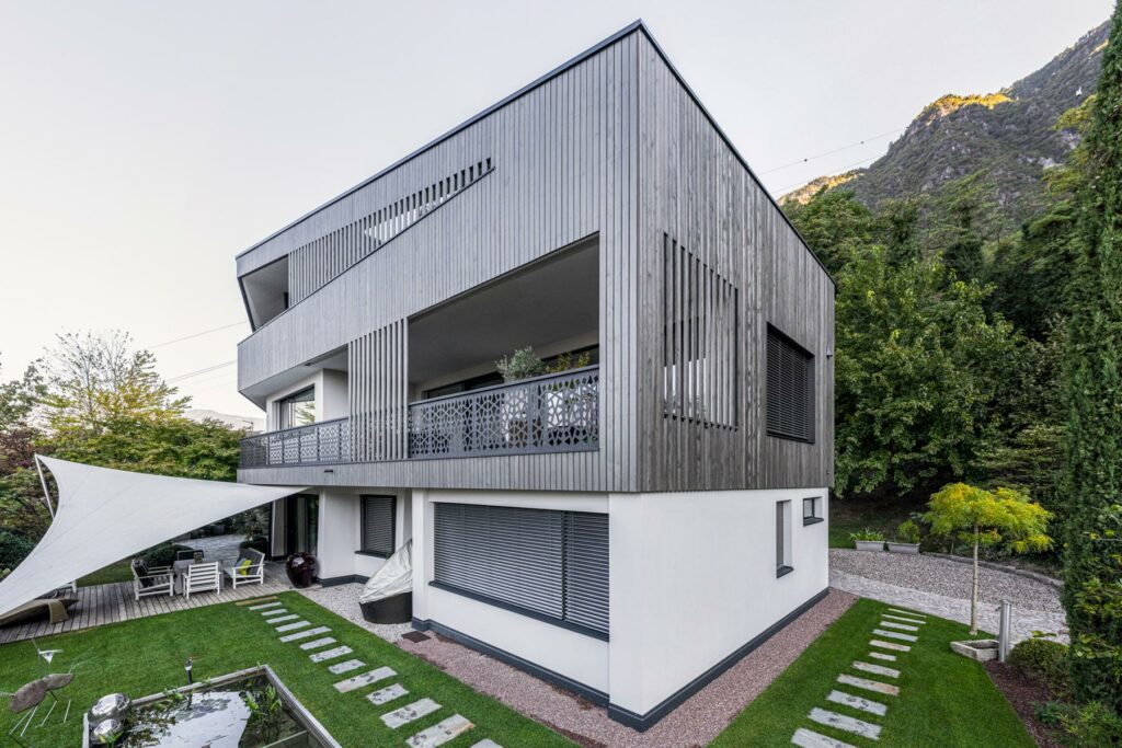 Modernes Holzhaus mit Garten in alpiner Umgebung