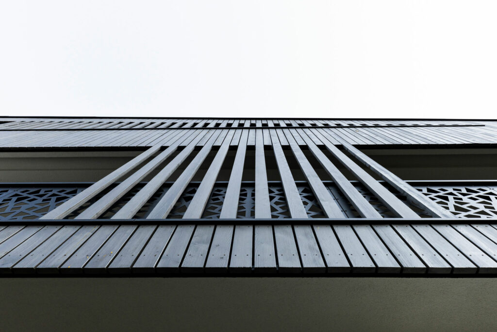 Moderne Gebäudefassade mit vertikalen Holzelementen und Ornamenten