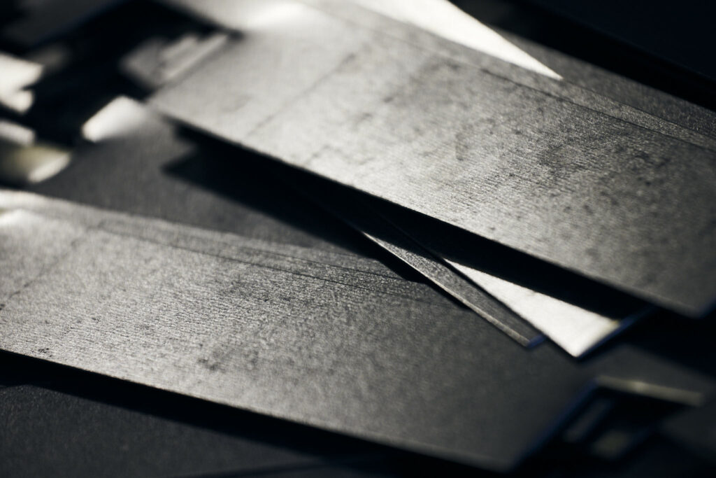 Nahaufnahme gestapelter Metallplatten mit Lichtreflexionen
