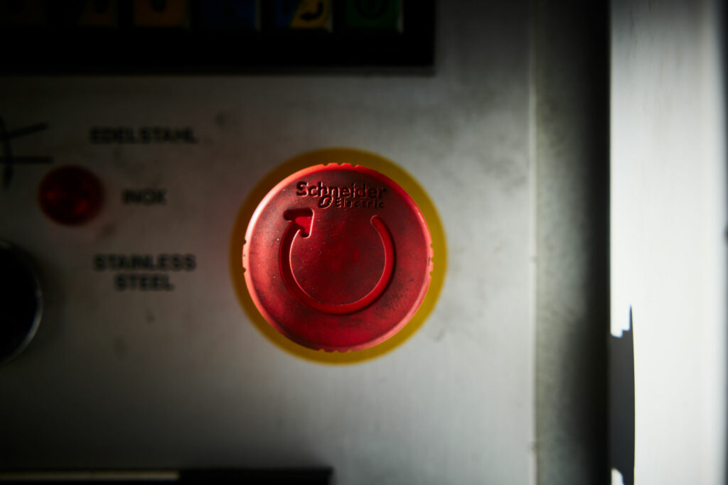 Großer roter Not-Aus-Knopf auf Industriemaschine.