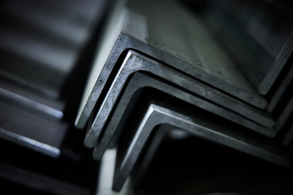 Detailaufnahme gestapelter Metallwinkel in düsterer Beleuchtung
