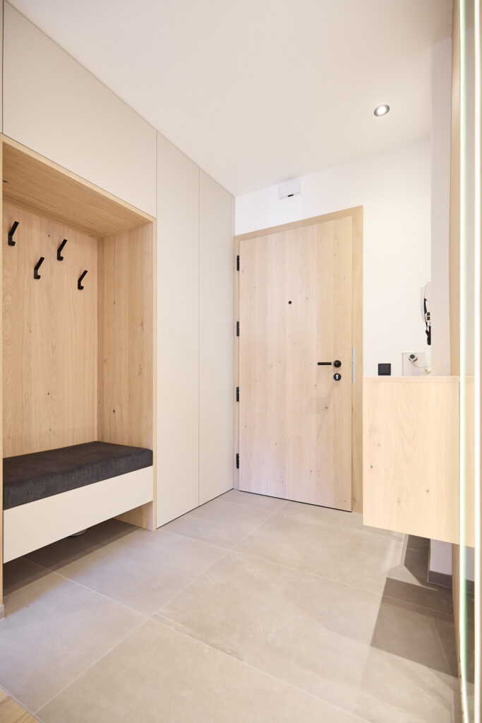 Moderner Eingangsbereich mit Holzverkleidung und Fliesenboden