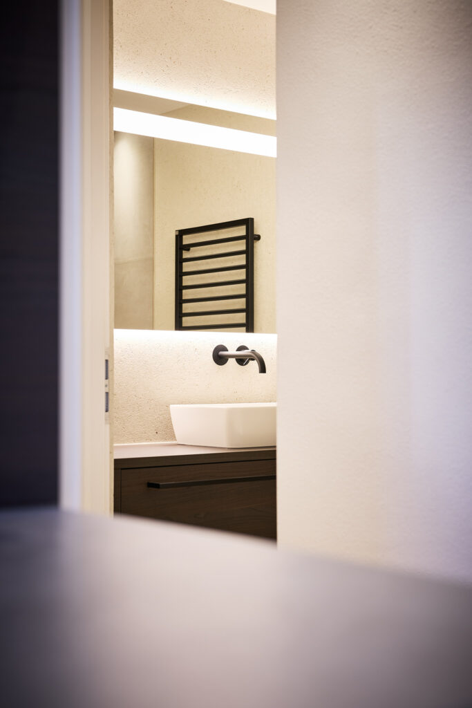 Modernes Badezimmer mit beleuchtetem Spiegel und Waschbecken