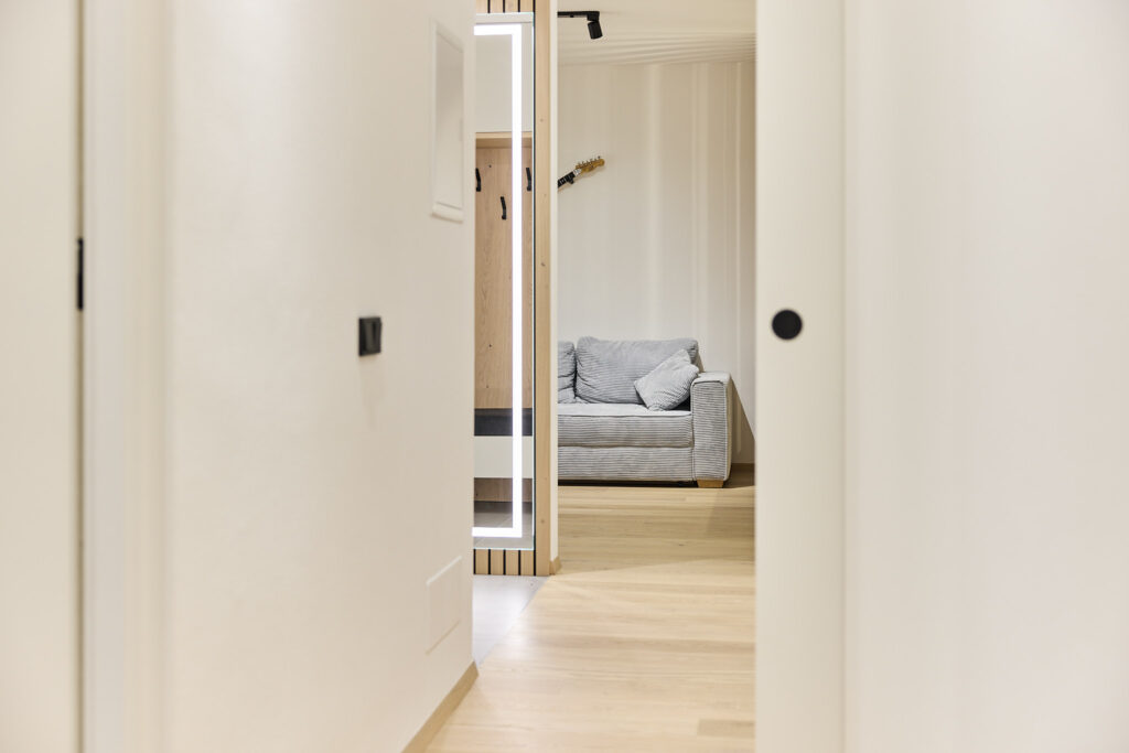 Heller Flur mit Blick auf graues Sofa im Zimmer