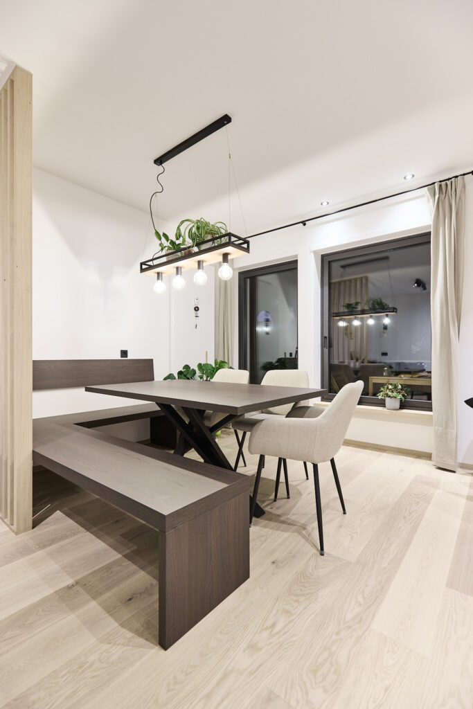 Moderner Essbereich mit Holztisch, Eckbank und hängender Pflanzenlampe