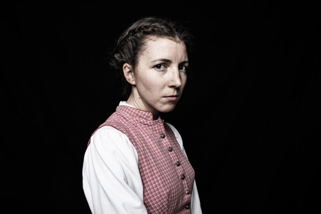 Frau in traditioneller Tracht vor schwarzem Hintergrund
