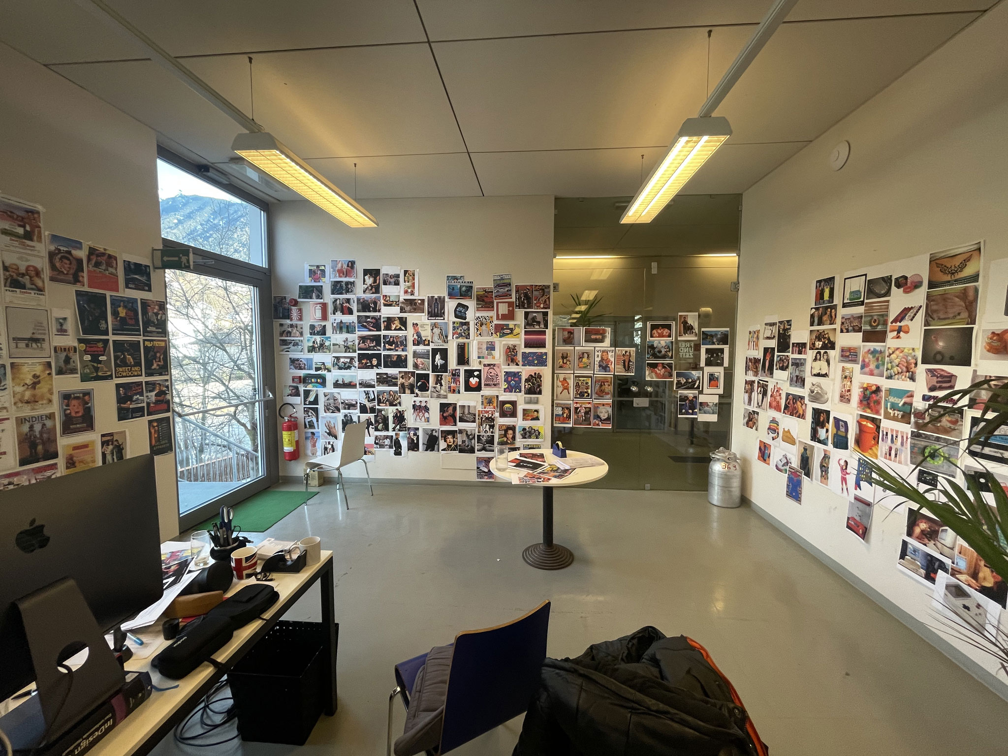 Kreativstudio mit Fotowand und Schreibtisch, Fenster mit Bergblick