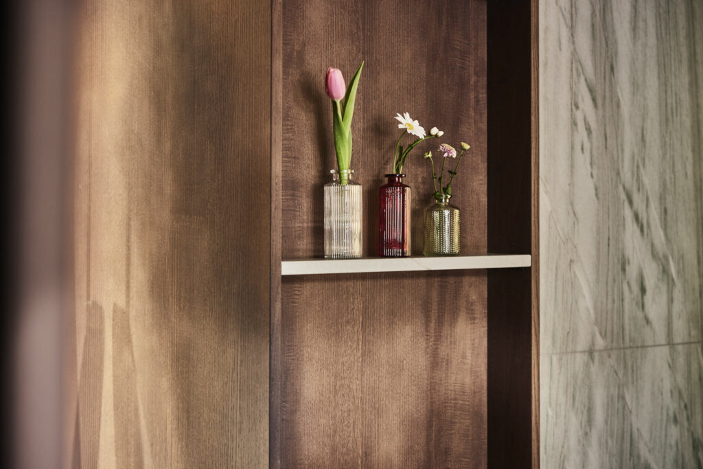 Holzregal mit drei Blumenvasen im Badhaus.
