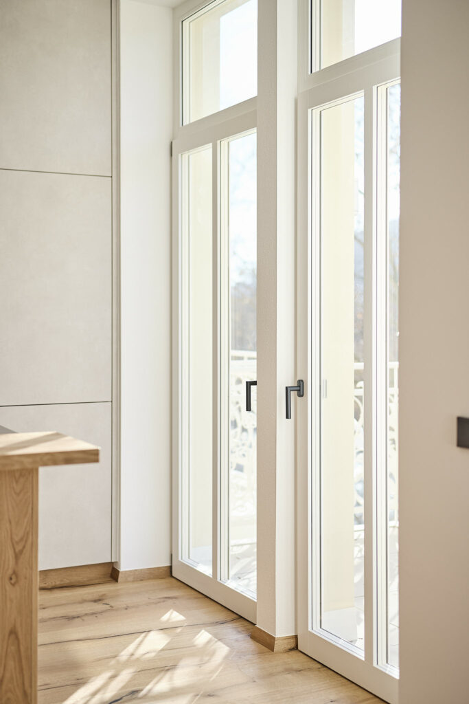 Heller Innenraum mit großer Fensterfront und Holzboden