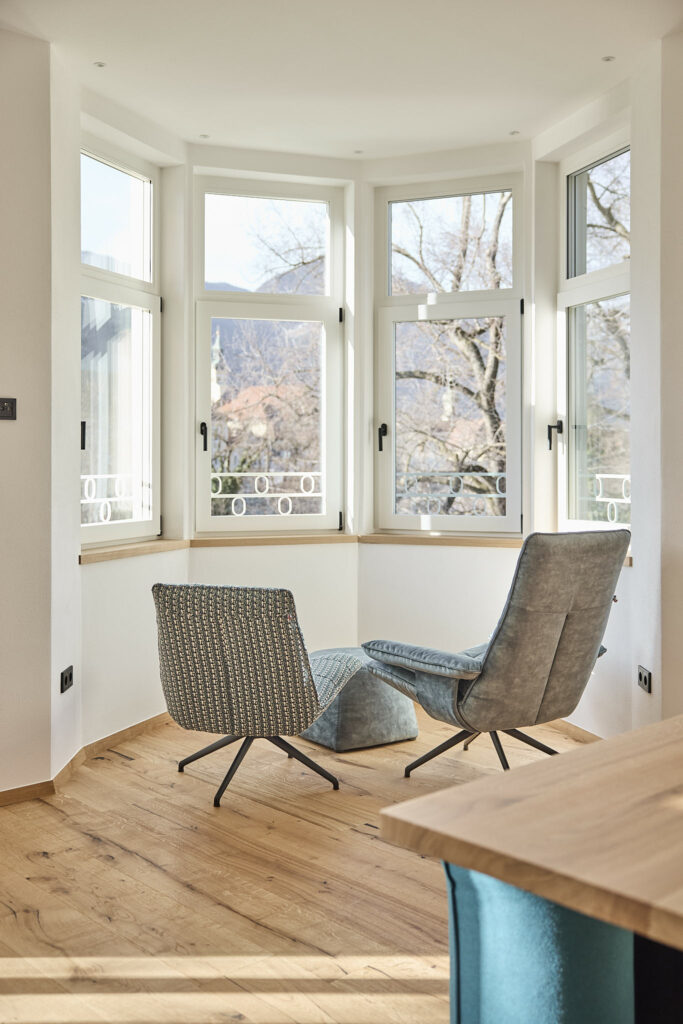 Helle Sitzecke mit Sesseln und großem Fensterblick