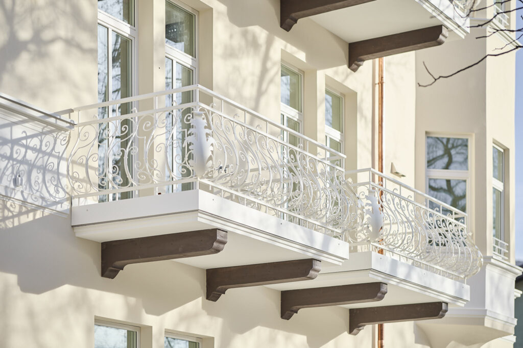 Sonnendurchflutete Balkone mit aufwendigem weißen Geländerdesign