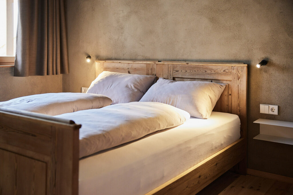 Gemütliches Schlafzimmer mit Holzrahmen-Bett in Burgerhof Ferienwohnung