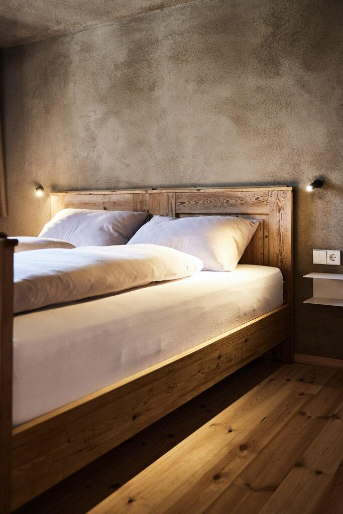Rustikales Schlafzimmer mit Holzbett und warmem Licht.