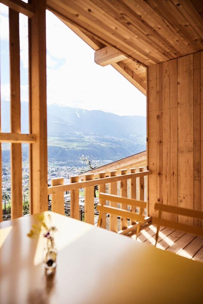 Holzveranda mit Bergblick und sonnendurchflutetem Tisch