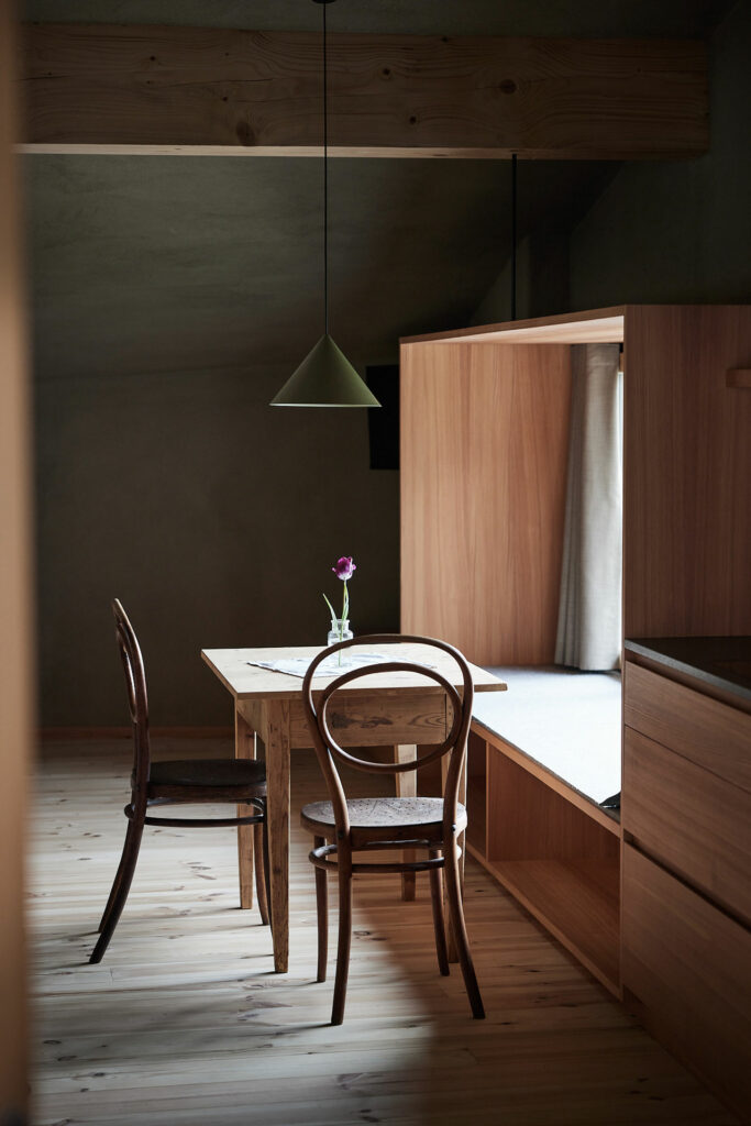 Rustikaler Essbereich mit Holztisch, Stühlen und Tulpe im Glas
