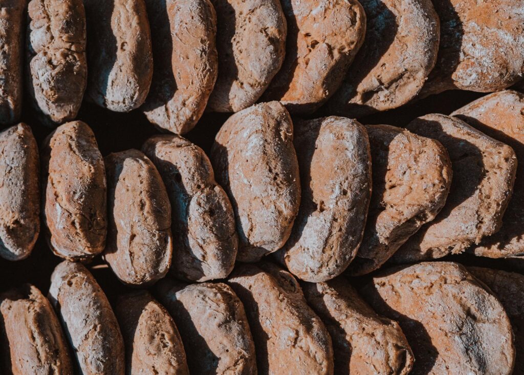 Nahaufnahme von mehreren frischen handgefertigten Brotleiben im Sonnenlicht