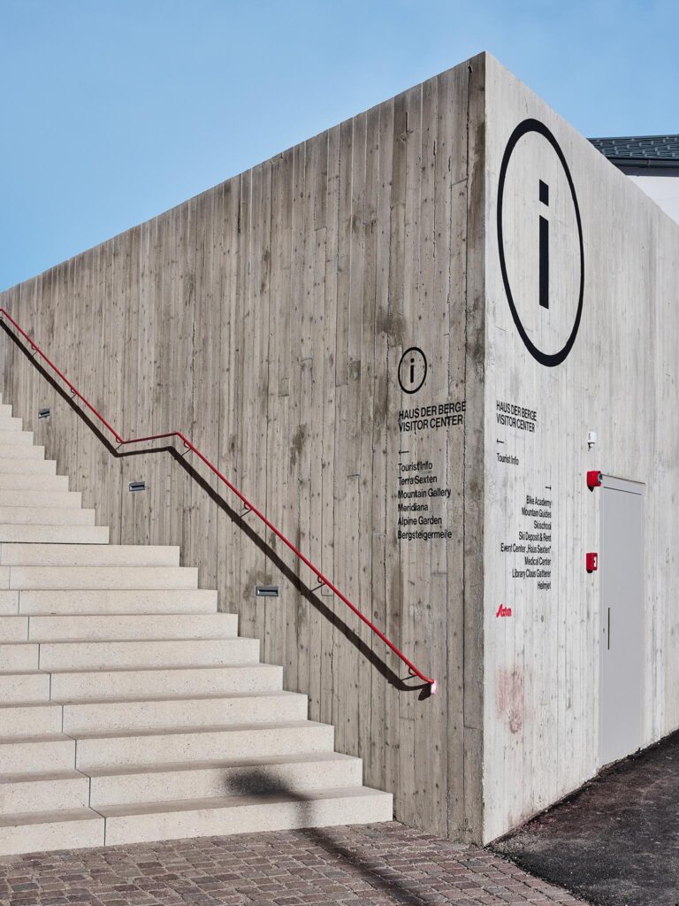 Betonwand mit Treppe und Tourist-Info-Symbol am Haus der Berge.