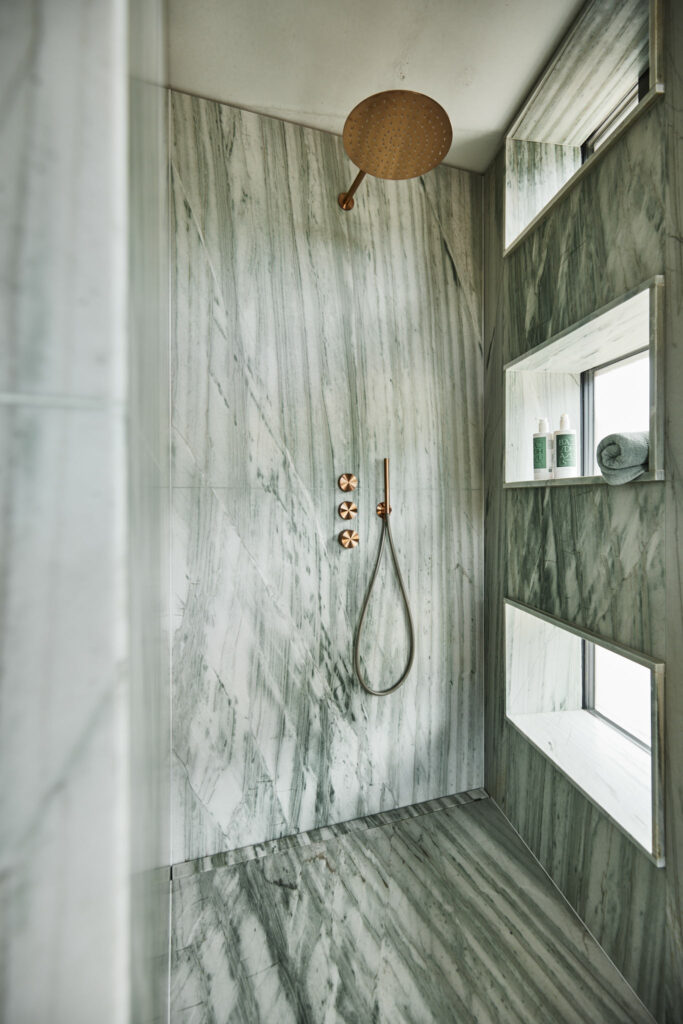 Moderne Dusche mit Marmorfliesen und Regendusche.