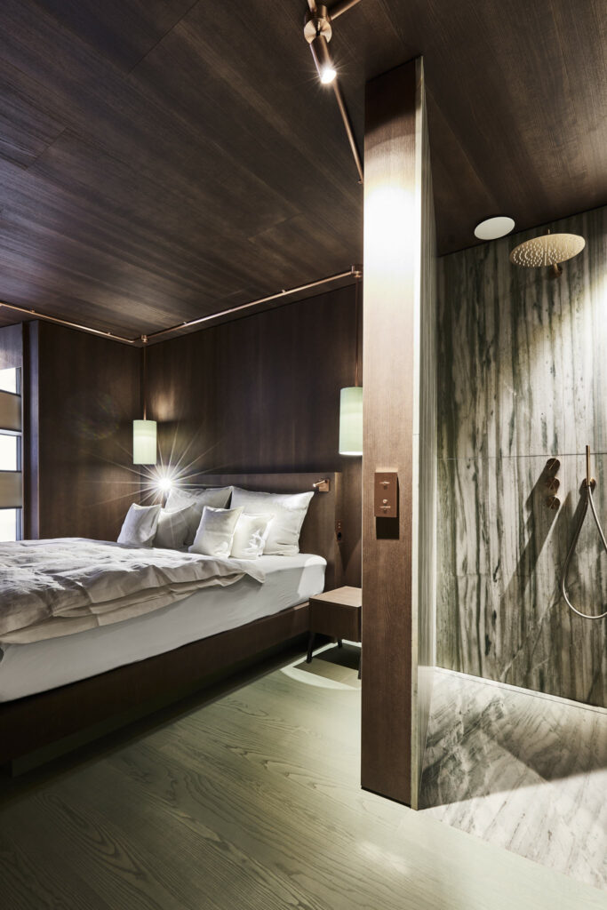 Modernes Hotelzimmer mit Holzverkleidung und offenem Badezimmerdesign