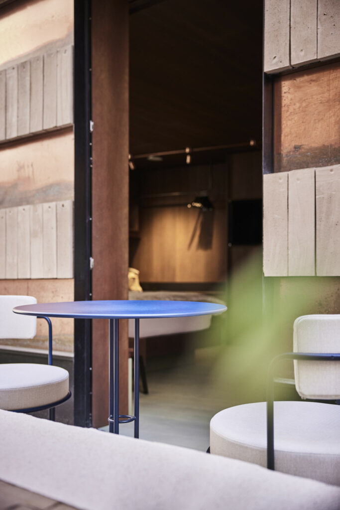 Moderner Innenhof mit blauem Tisch und Stühlen