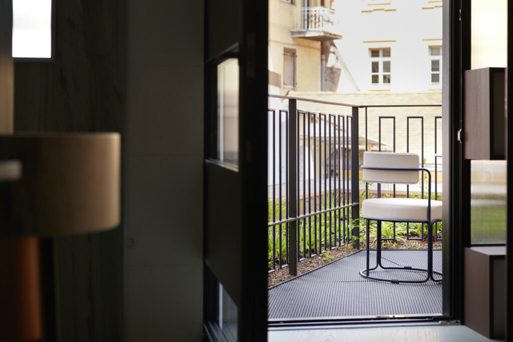 Moderner Stuhl auf kleinem Balkon vor Stadtgebäude