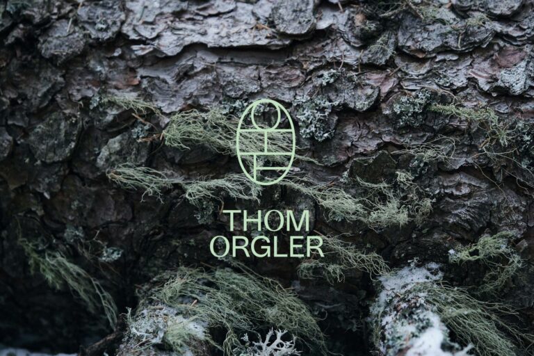 Logo und Name Thom Orgler auf Baumrinde mit Flechten