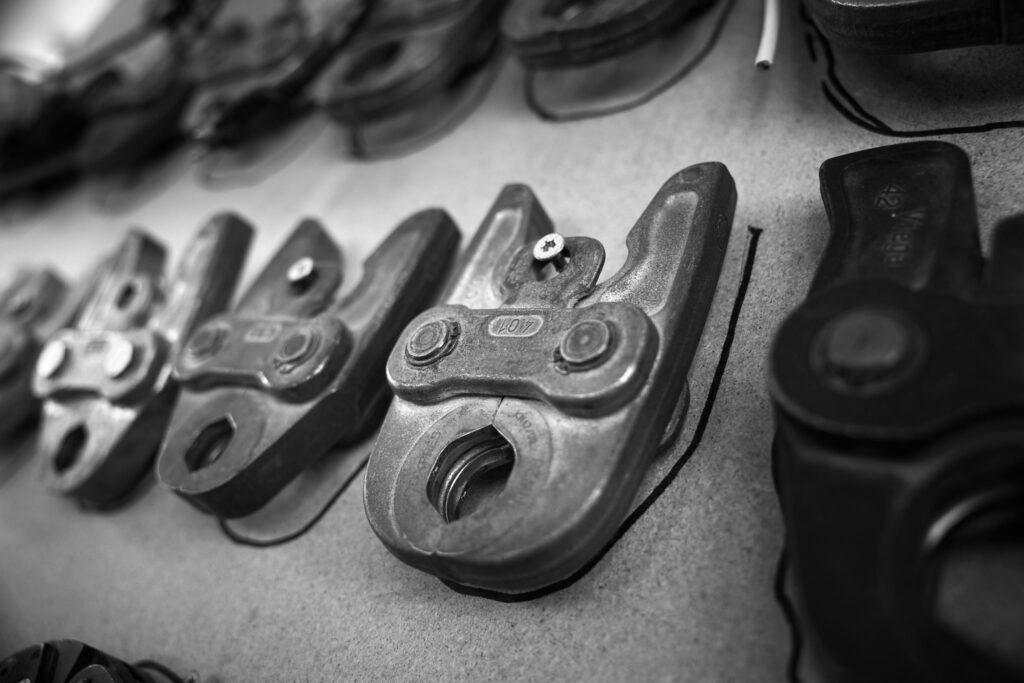 Nahaufnahme metallischer Werkzeuge an Werkstattwand