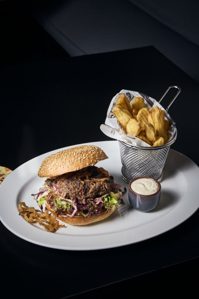Burger mit Salat und Pommes im Metallkorb