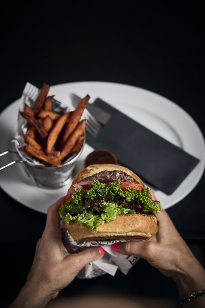 Burger mit Salat und Pommes frites auf Teller
